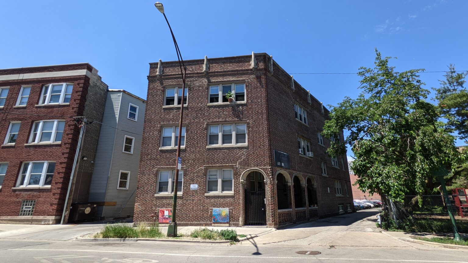 The brick facade and arched entrance of Red Line Flats on North Rogers Avenue